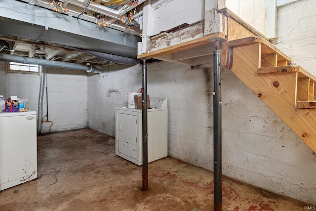 basement featuring washing machine and dryer and fridge