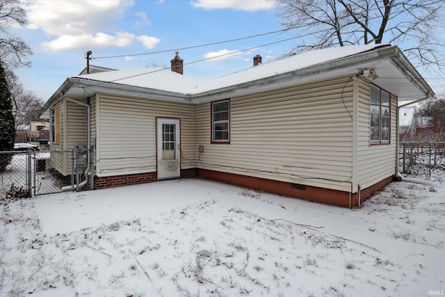 view of snow covered back of property