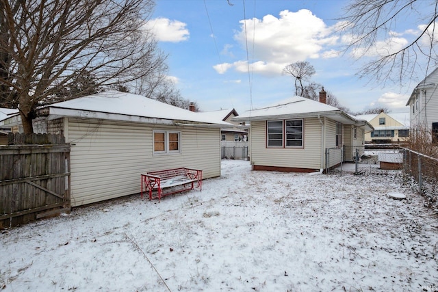 view of snow covered back of property