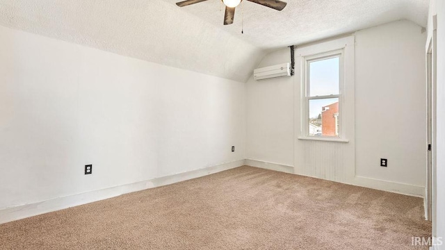 bonus room with ceiling fan, a wall unit AC, a textured ceiling, lofted ceiling, and carpet