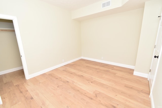 unfurnished bedroom with light hardwood / wood-style flooring and a closet