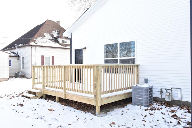 snow covered property featuring central air condition unit and a deck