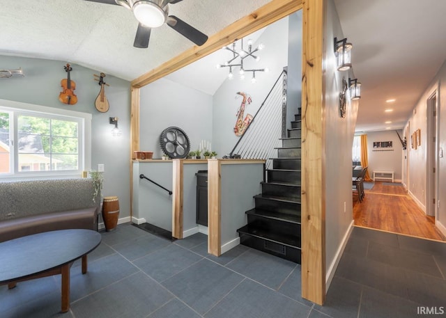 interior space featuring tile patterned floors, ceiling fan, a textured ceiling, and vaulted ceiling