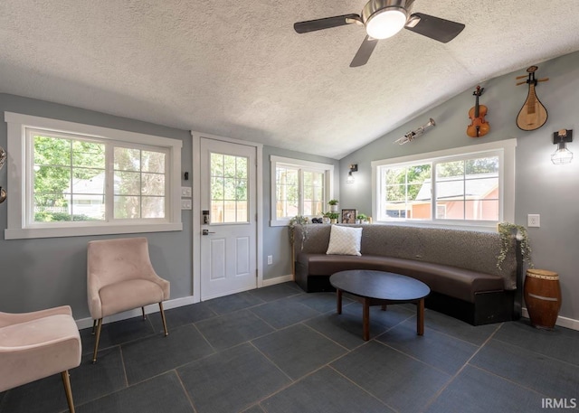 living room featuring a textured ceiling, ceiling fan, plenty of natural light, and vaulted ceiling