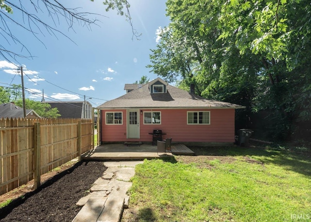 rear view of property featuring a yard and a wooden deck