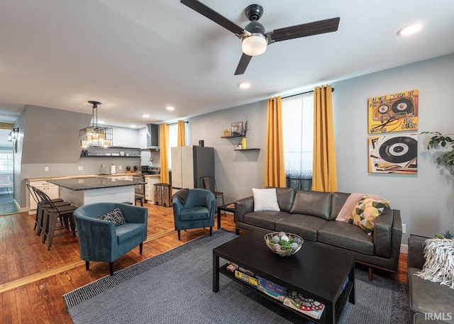 living room featuring ceiling fan, hardwood / wood-style floors, and sink