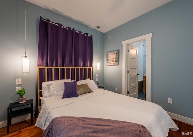 bedroom featuring wood-type flooring and ensuite bath