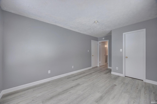 unfurnished bedroom featuring a textured ceiling and light hardwood / wood-style floors