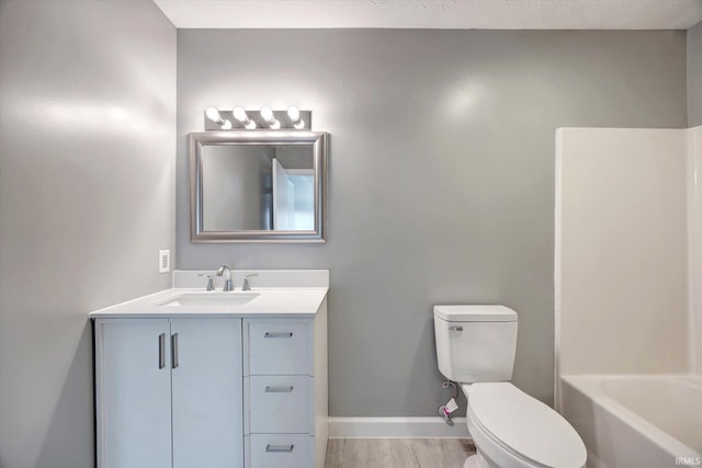 bathroom with hardwood / wood-style floors, vanity, and toilet