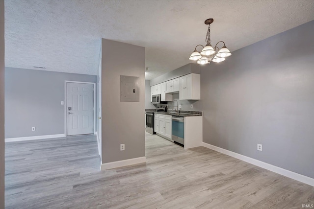 kitchen with electric panel, an inviting chandelier, sink, white cabinetry, and stainless steel appliances