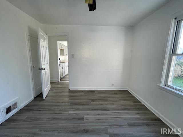 empty room with ceiling fan and dark wood-type flooring