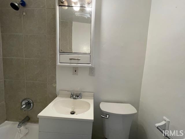 full bathroom featuring vanity, tiled shower / bath combo, and toilet