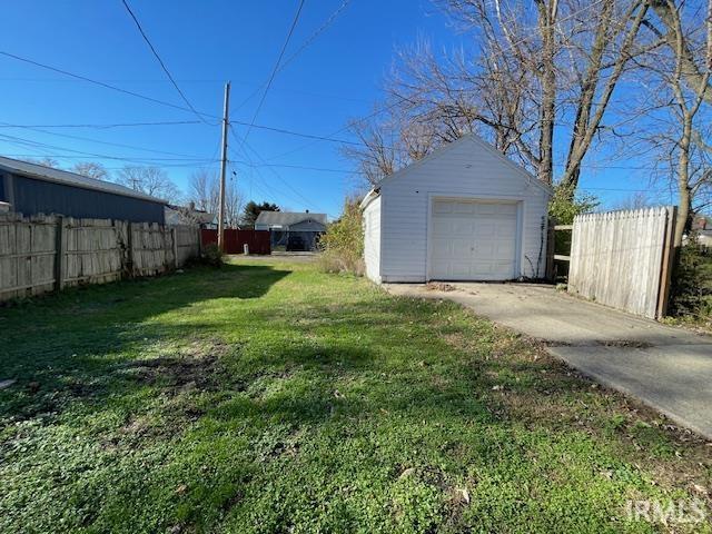 view of yard featuring a garage and an outdoor structure