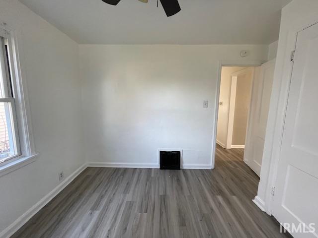 unfurnished room with dark hardwood / wood-style flooring and ceiling fan