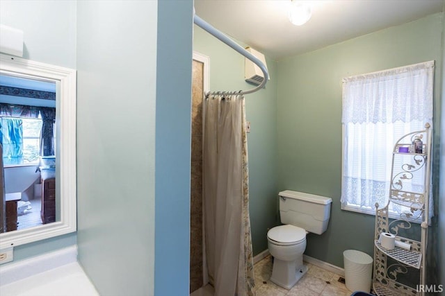 bathroom featuring tile patterned flooring, a shower with curtain, and toilet