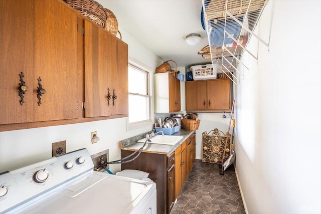 laundry area featuring cabinets, washing machine and clothes dryer, and sink