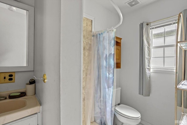 bathroom with curtained shower, vanity, and toilet