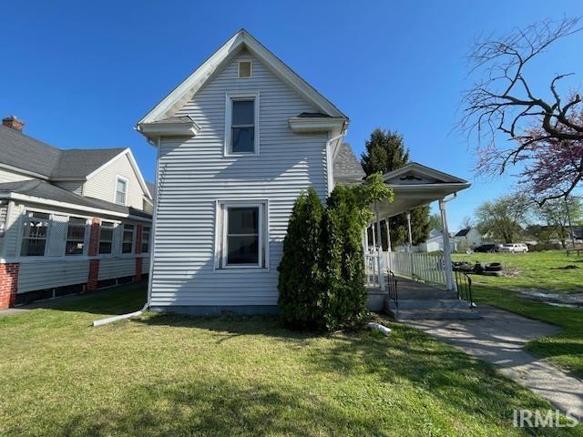 rear view of property with a lawn