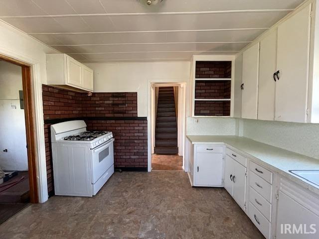 kitchen featuring white cabinetry and white gas stove