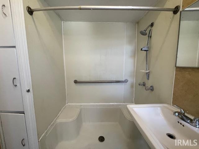 bathroom featuring walk in shower and sink