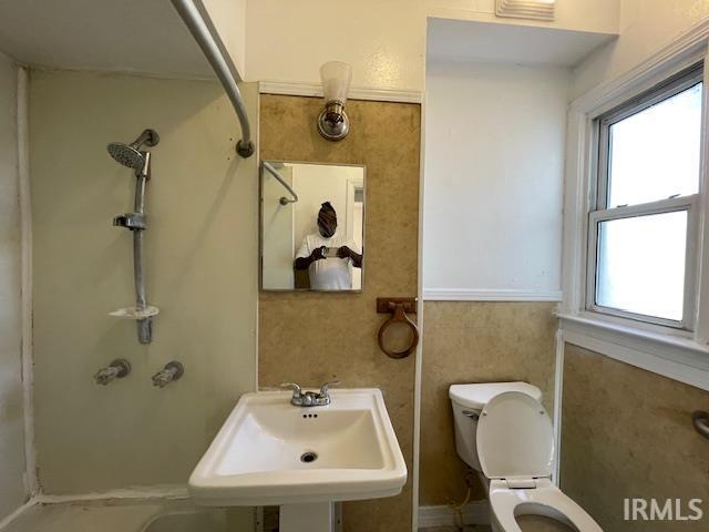 bathroom featuring a healthy amount of sunlight, toilet, and sink