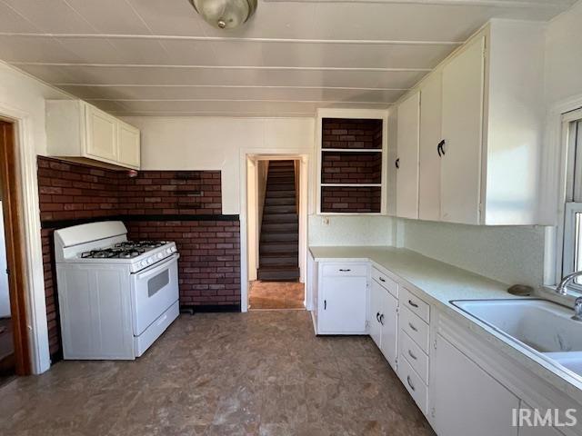 kitchen with white cabinets, sink, and white gas range oven