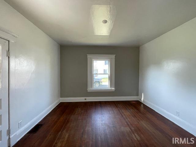 spare room with dark hardwood / wood-style floors