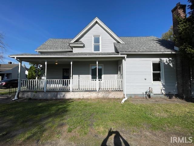 view of front of house featuring covered porch and a front yard