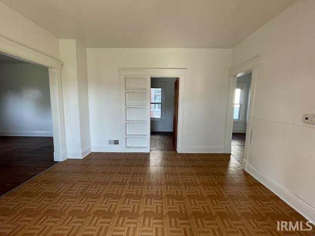 spare room with dark parquet flooring