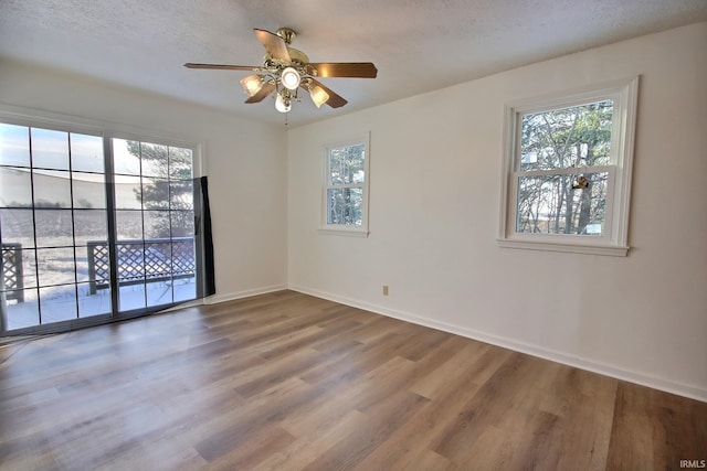 unfurnished room with a textured ceiling, hardwood / wood-style flooring, and ceiling fan