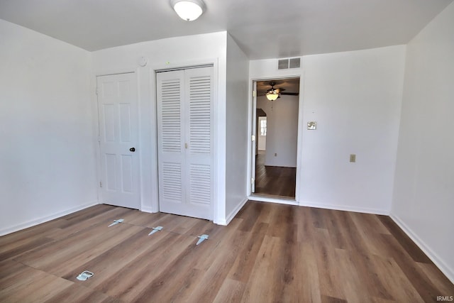 unfurnished bedroom featuring a closet and dark wood-type flooring