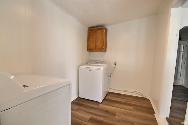 clothes washing area featuring crown molding, cabinets, dark hardwood / wood-style floors, and independent washer and dryer