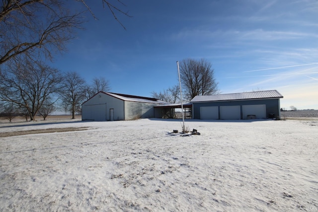 snow covered house with an outbuilding and a garage