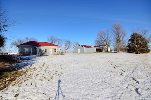 yard covered in snow featuring an outbuilding