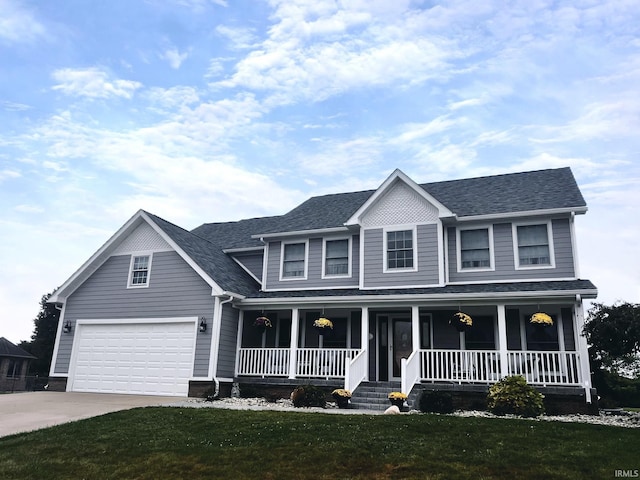 view of front of property featuring a porch, a garage, and a front lawn