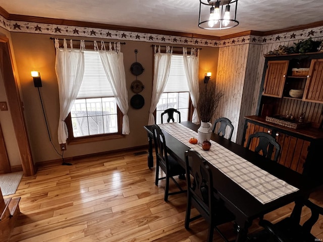 dining space with plenty of natural light, light wood-type flooring, and crown molding