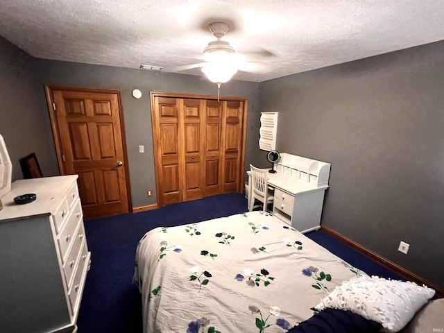 carpeted bedroom featuring ceiling fan, a closet, and a textured ceiling