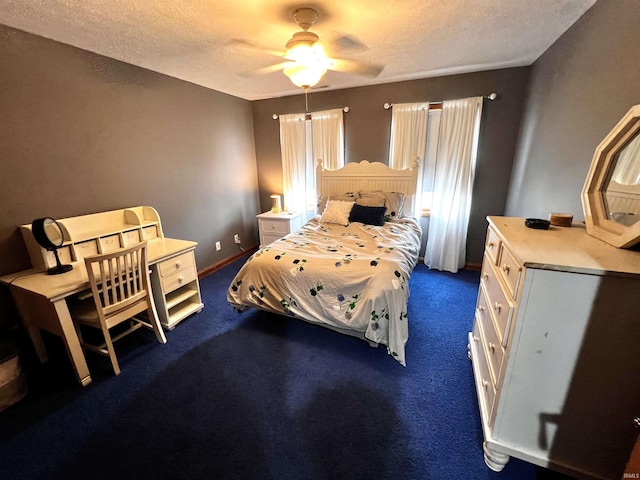 bedroom with ceiling fan, dark carpet, and a textured ceiling