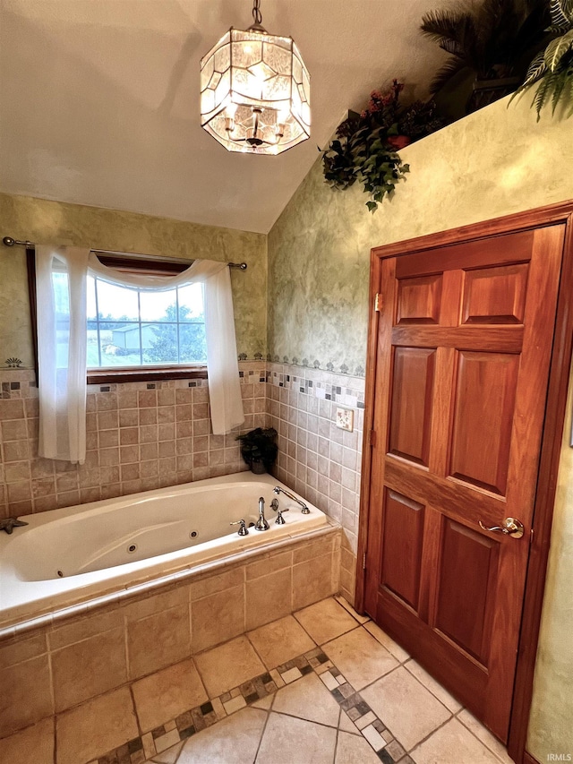 bathroom featuring tile patterned flooring, tiled bath, and vaulted ceiling