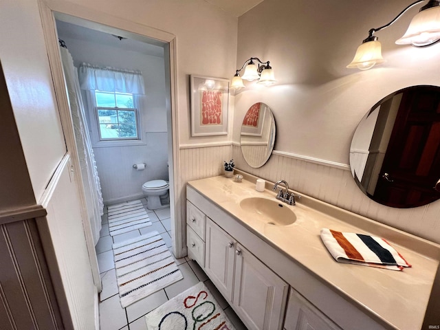 bathroom with tile patterned flooring, vanity, and toilet