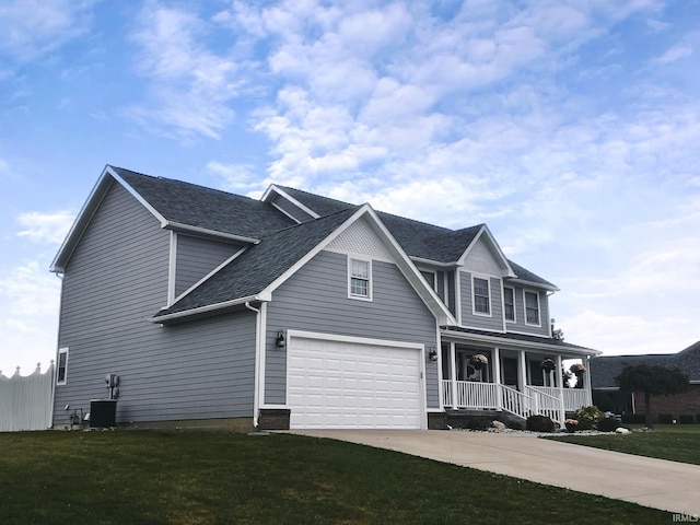 view of front of house with central air condition unit, covered porch, a front yard, and a garage