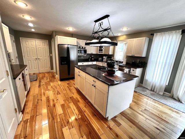 kitchen with appliances with stainless steel finishes, a center island, decorative light fixtures, and white cabinetry