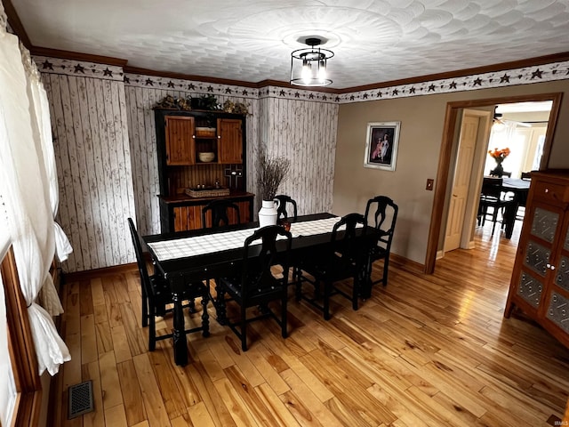 dining space with a textured ceiling and light hardwood / wood-style floors