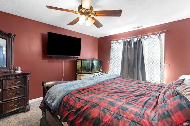 carpeted bedroom featuring ceiling fan and a textured ceiling