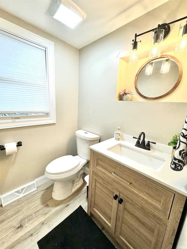 bathroom with wood-type flooring, vanity, and toilet