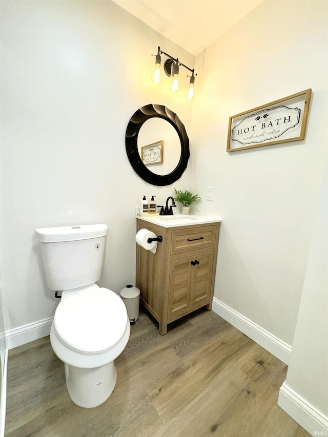 bathroom with vanity, toilet, and wood-type flooring