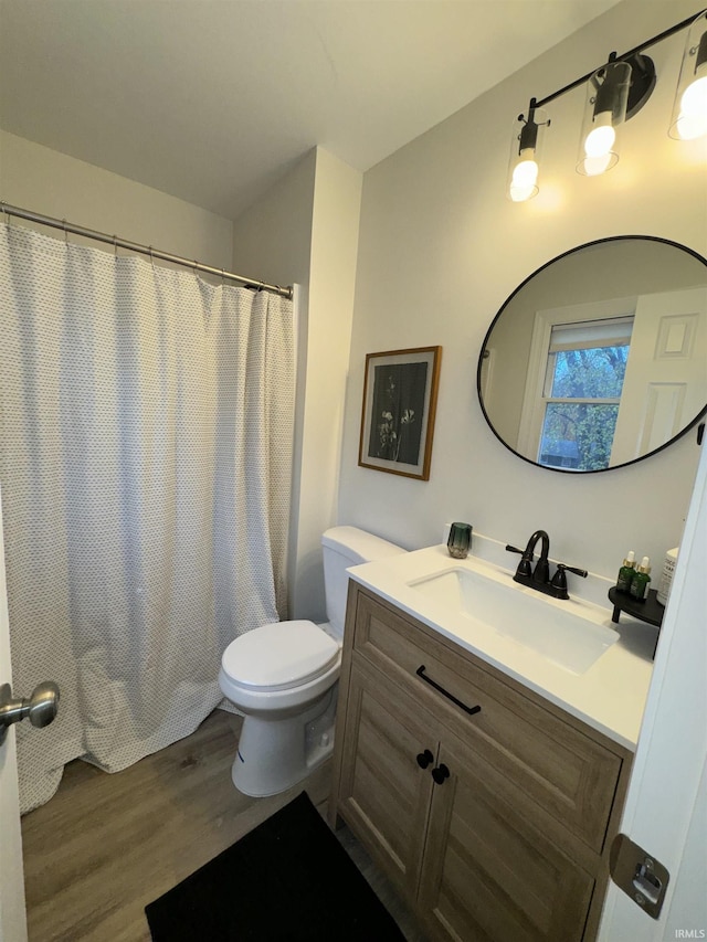 bathroom featuring a shower with shower curtain, vanity, wood-type flooring, and toilet