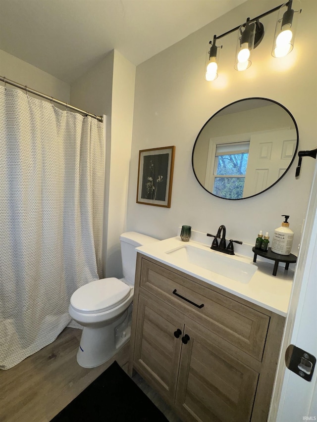 bathroom with hardwood / wood-style floors, vanity, and toilet