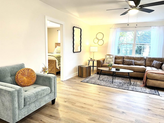 living room with light wood-type flooring and ceiling fan