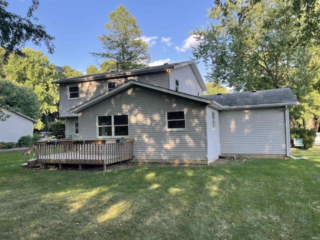 back of house featuring a lawn and a wooden deck